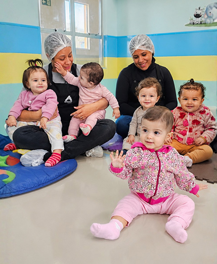 Educadora do berçário no colo de um bebê