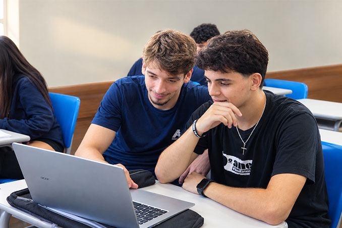 Alunos do Ensino Médio trabalhando juntos em um notebook